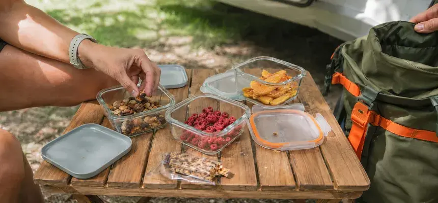 Geöffnete Boxen mit Nüssen, gefriergetrockneten Früchten und Snacks auf dem Campingplatz