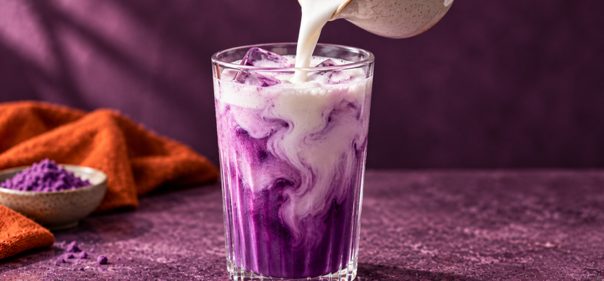 Eingießen von Milch in ein lila ube latté